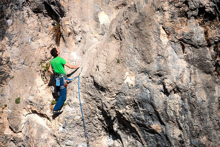 一个人爬上岩石在大自然中攀爬户外健身积极的生活方式极限员在自图片