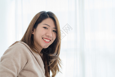 快乐美丽的年轻亚洲女人早上醒来图片