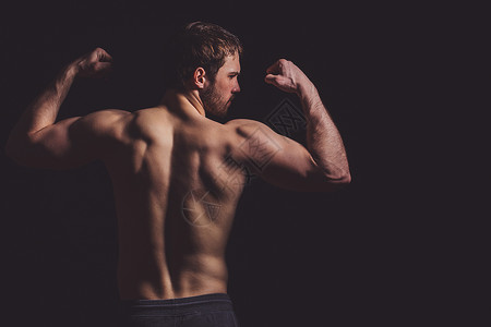 年轻健美运动员用肌肉来定义身体的紧身图片