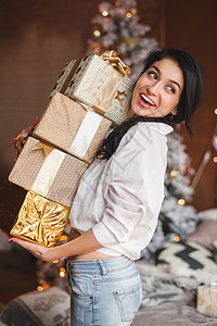 怀着圣诞节礼物的微笑女人在圣诞节图片