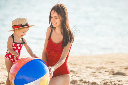 年轻的母亲带着小女儿在沙滩上玩耍图片