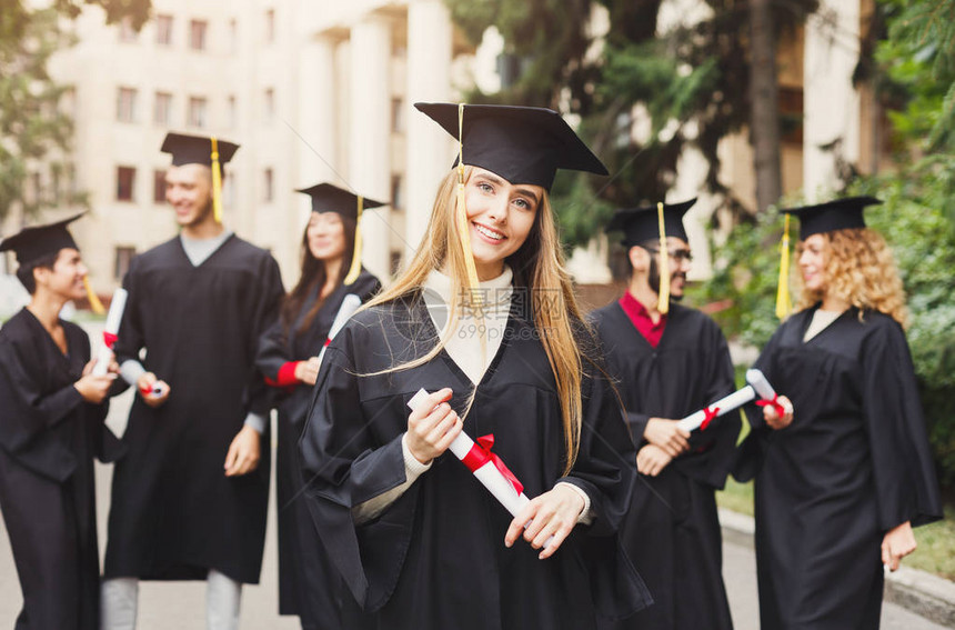 年轻微笑的女人在大学毕业那天与多民族的朋友站在一起教育资图片