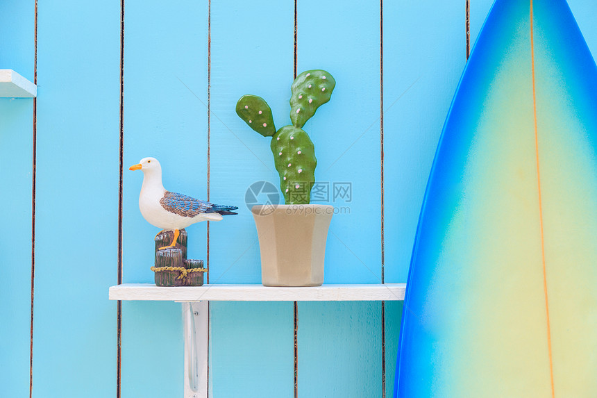 一个海鸥模型和一个在架子上罐子里的仙人掌以及蓝面图片