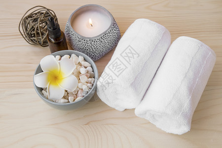 Spa设置静物与毛巾弗朗西帕尼花和木制背景上的蜡烛背景图片