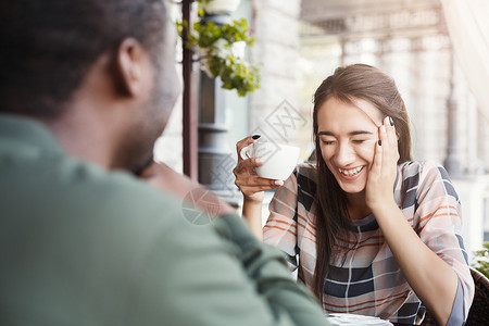 年轻无聊的女孩坐在咖啡馆和男友约会时使用智能手机快速约会图片