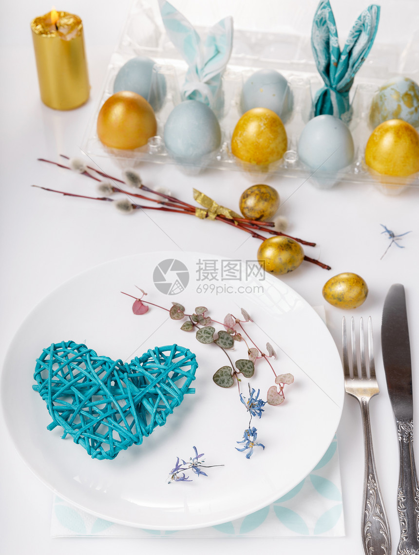 复活节桌配有金蓝蛋和餐具假日背图片