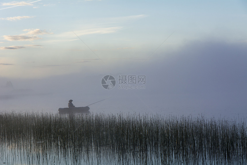 雾中湖上的渔夫图片