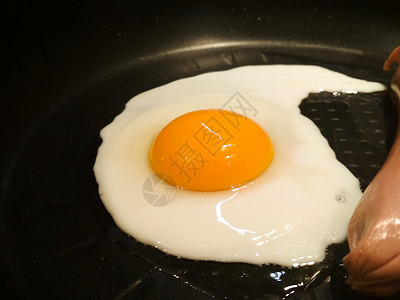 在平底锅里煎鸡蛋和香肠煎鸡蛋的特写图片