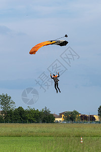 与橙兰花降落伞对抗蓝天的伞兵图片