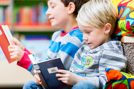 两个男孩在图书馆看书玩得开心两图片