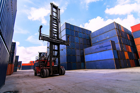 叉车在船厂或船坞在日出天空下提升货物集装箱图片