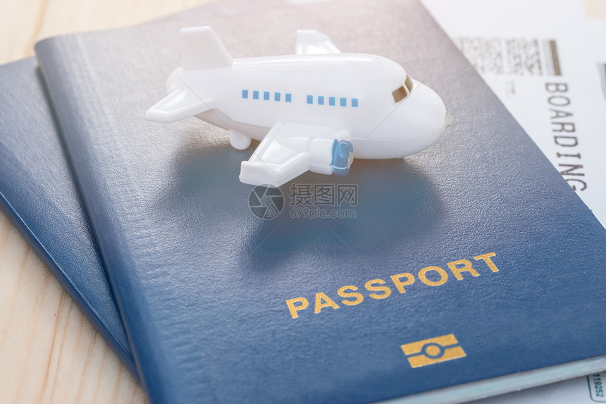 小玩具飞机挂在蓝色护照上有木质图片