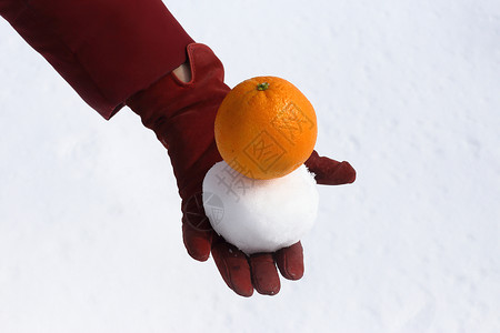女人的手戴套保持雪和橙色白图片