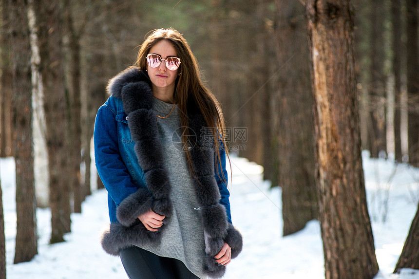 在冬季森林的年轻时装女士玩得开图片