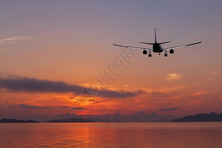 飞机在美丽颜色日落或日出风景背下飞越热图片