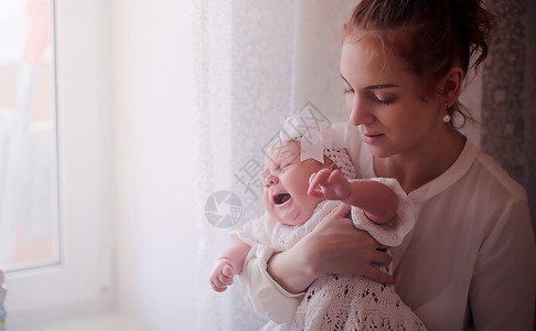 妈怀里抱着一个刚出生的婴儿女孩在窗前抱着一个婴儿母亲图片