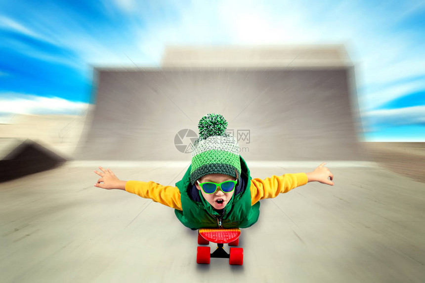 小男孩在陡峭的山上骑着滑图片