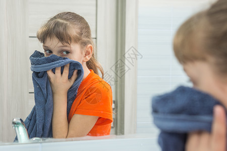 孩子在浴缸里用干净的毛巾擦脸图片