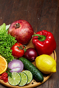 木制盘子上新鲜有机水果和蔬菜的多彩静物图片