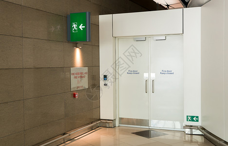 机场航站楼紧急出口方式的消防出口方式门和消防出口标志灯箱紧急标志情况下的绿色紧急出背景图片