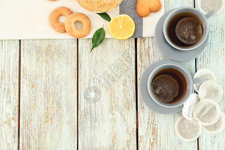 茶包和杯子木制背景上的热饮图片