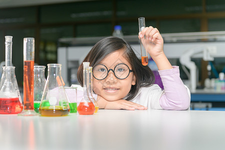 穿着实验室外套的快乐科学家女孩在化学实验室科学和教育理念中图片