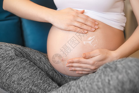 特写孕妇在她的腹部涂抹保湿霜以预防妊娠纹怀孕怀孕产品保健预图片