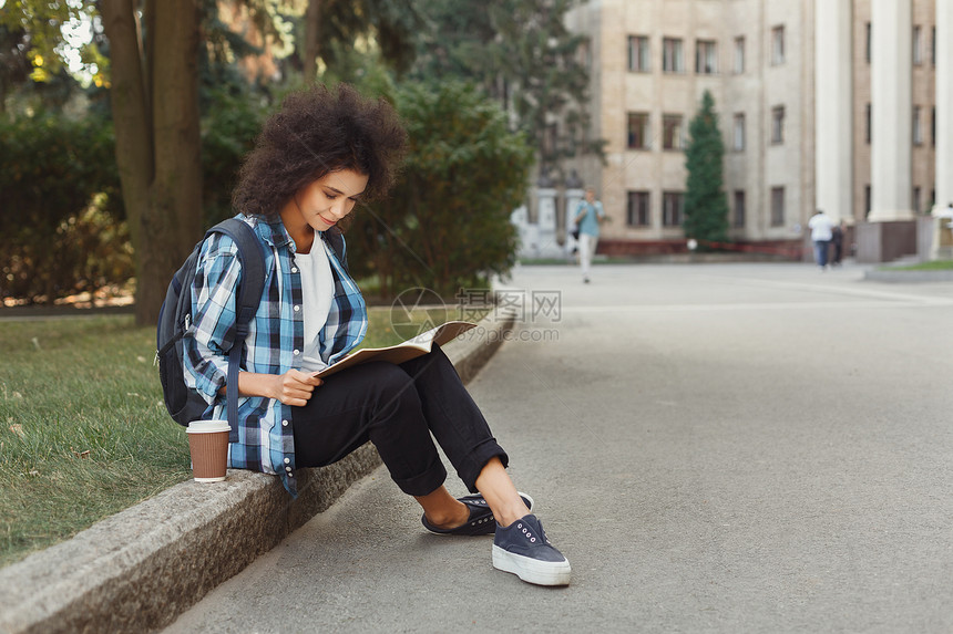 年轻的非洲美洲妇女阅读笔记在大学上习和准备考试检查时间表教育概念复制空间图片