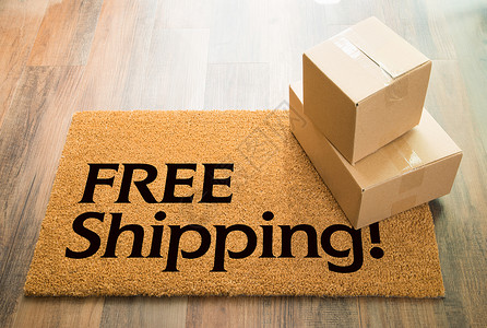 木地板上的免费送货欢迎垫与包装盒运图片