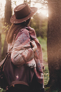 时尚的时髦旅行者女孩戴着帽子和雨披图片