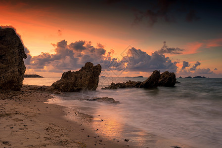 日出时自然石拱门的海景和泰国Rayong海滩的黄昏天空大阻塞器在热带运动模糊的海洋中背景图片