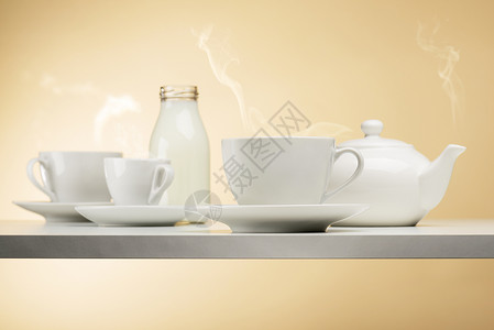 用茶壶在白桌上蒸杯茶图片