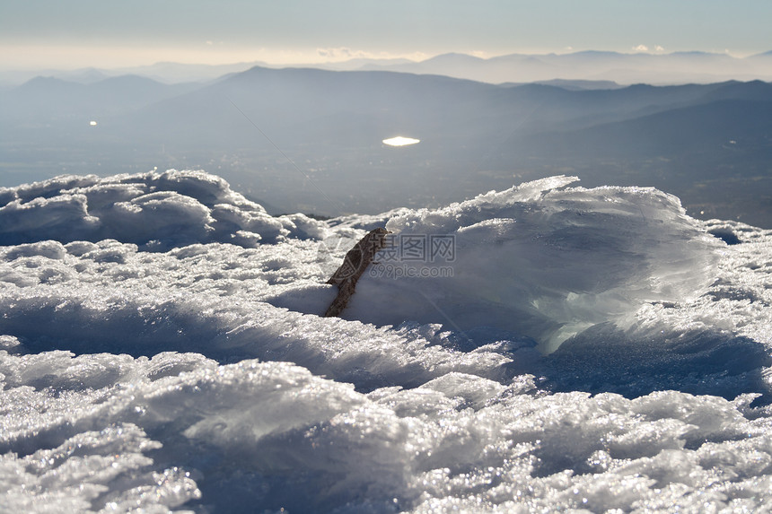 风和雪在西班牙马德里纳瓦塞拉达的瓜达拉马山脉自然公园的BoladelMundo的山脉山谷和薄雾的地平线上形图片