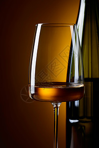 黄色背景的酒杯和白葡萄酒图片