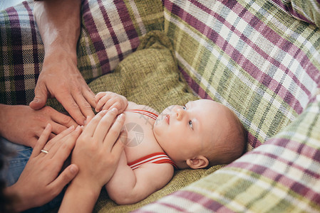 手放在婴儿肚子上刚出生的婴儿躺在扶手椅上母亲和父亲节的概念家庭图片