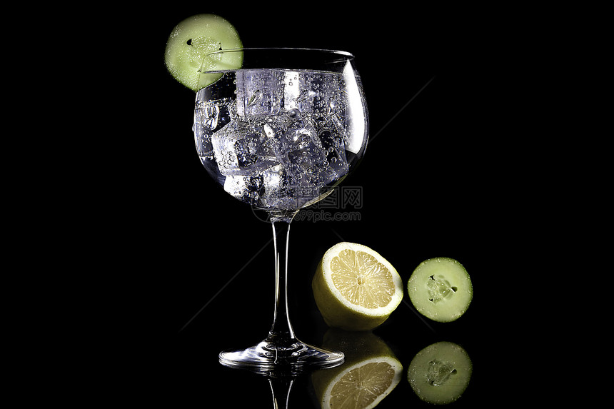 黑色背景上加柠檬和黄瓜的杜松子酒图片