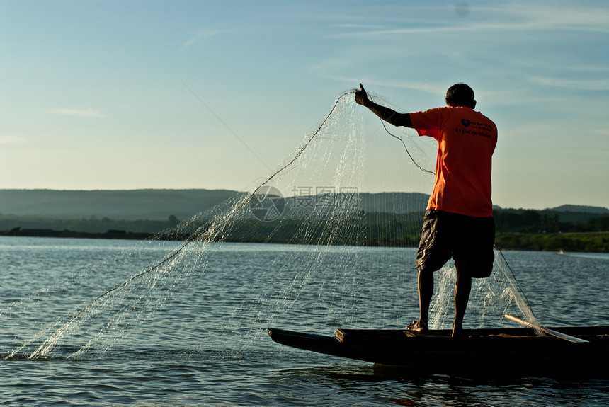 日落时分男子在湄公河的田野里钓鱼图片