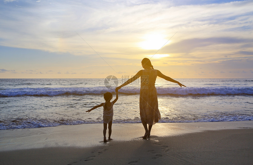 日落时分母女俩在沙滩上放松图片