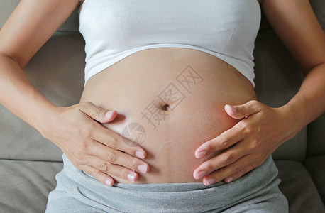 孕妇在腹部皮肤上涂奶油孕期图片