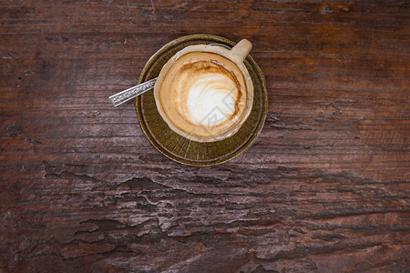 木桌上石杯中的拿铁艺术热咖啡香气饮用图片