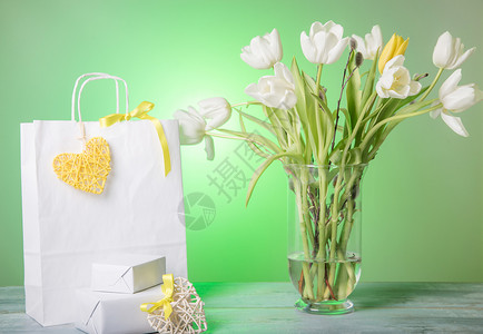 购物袋黄心和丝带礼物和白色春天花束郁金香图片