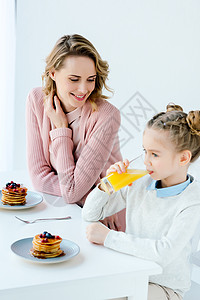 母亲和女儿在餐桌上一起吃早图片