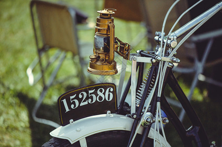 一辆旧摩托车的黄铜煤油车头灯弹簧前叉和一个旧号码图片
