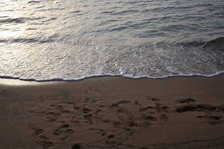沙滩大海日出中的脚印图片