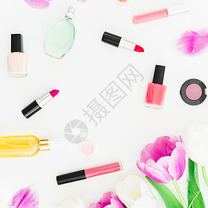 白色背景的女化妆品香水梳子和郁金香花图片