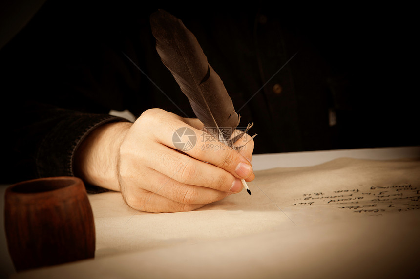 作家拿着钢笔在写纸和写诗图片