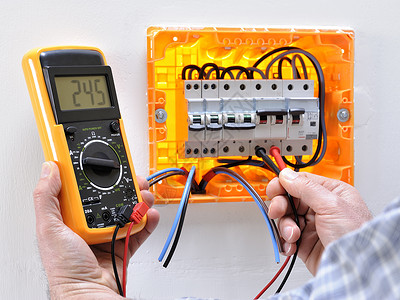 在住宅电气面板上工作的电工技术人员测量热磁断路器图片