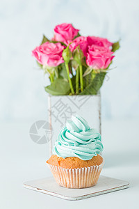 Cupcake与温柔的蓝奶油在蓝色面粉背景垂直横幅婚礼或生日派对邀请图片