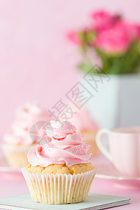 装饰着纸杯蛋糕一杯加牛奶的咖啡和一束粉红玫瑰图片