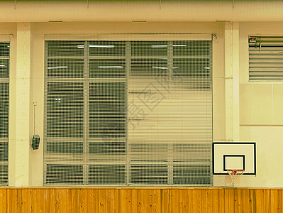 室内体育馆内装有篮球板和篮子窗户上的安全网荧光背景图片